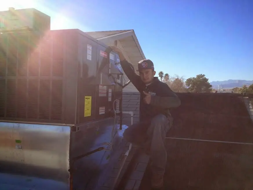 HVAC technician performing Heat Pump Repair on a rooftop unit in Quartz Hill
